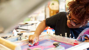 woman with glasses working with paint
